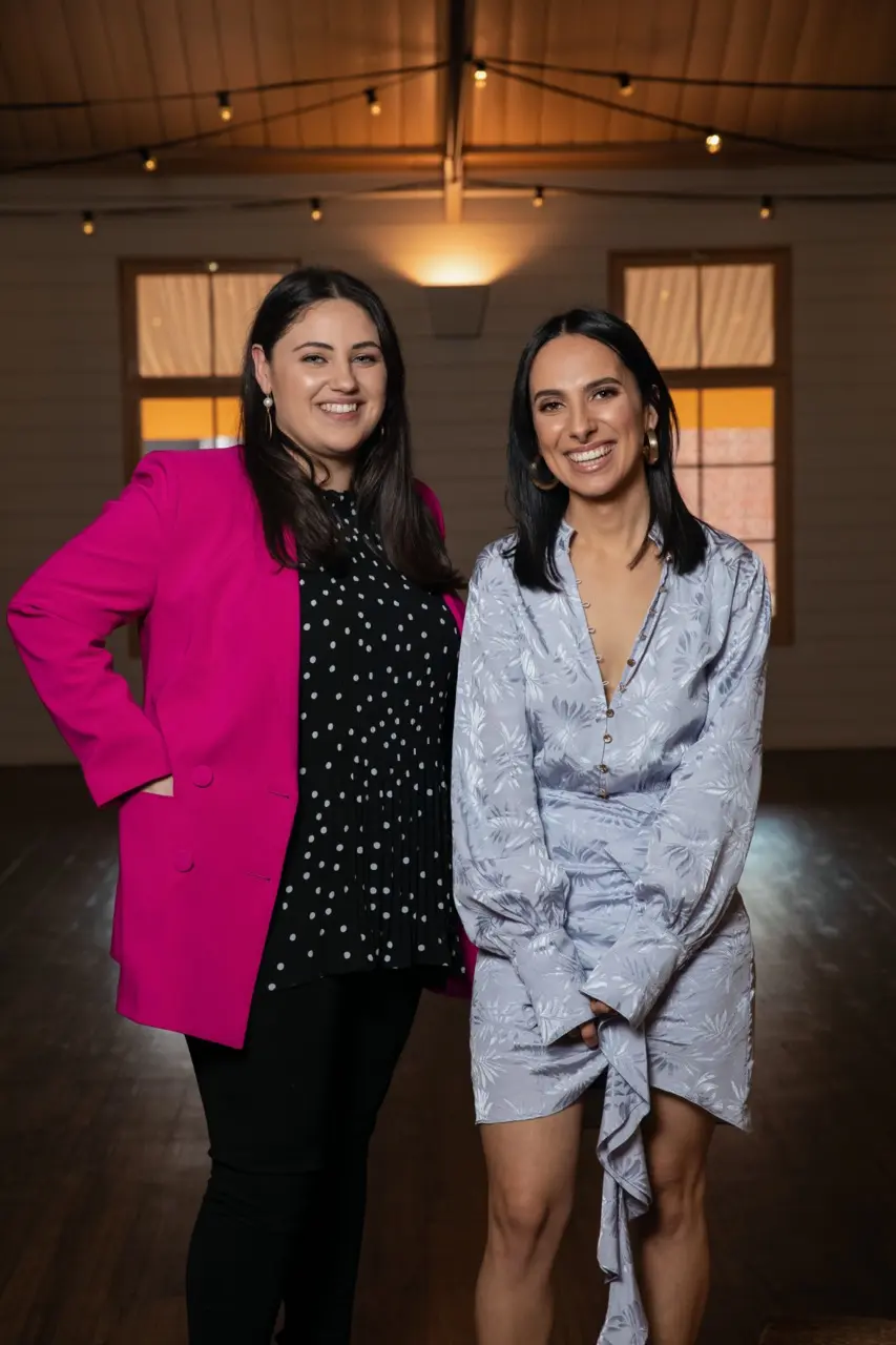 Owners Angela and Sundy smiling at the camera in elegant attire.